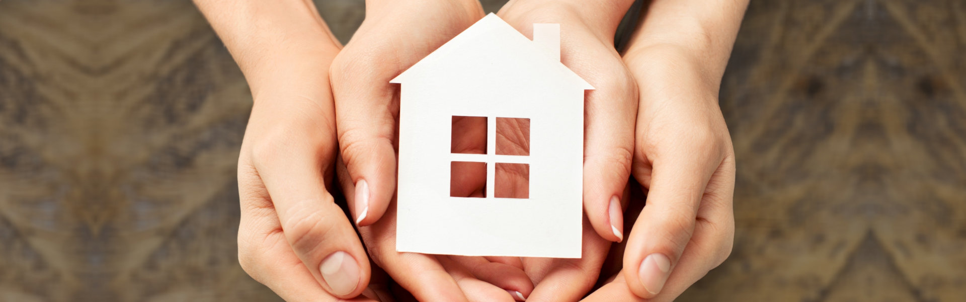 Hands holding house model